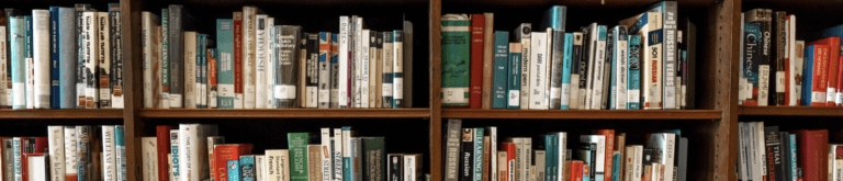 A bookshelf at the library is stuffed full of books.