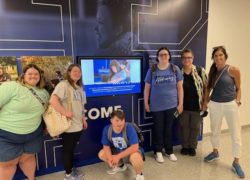 A group of students gather around a television in the UK Student Center.